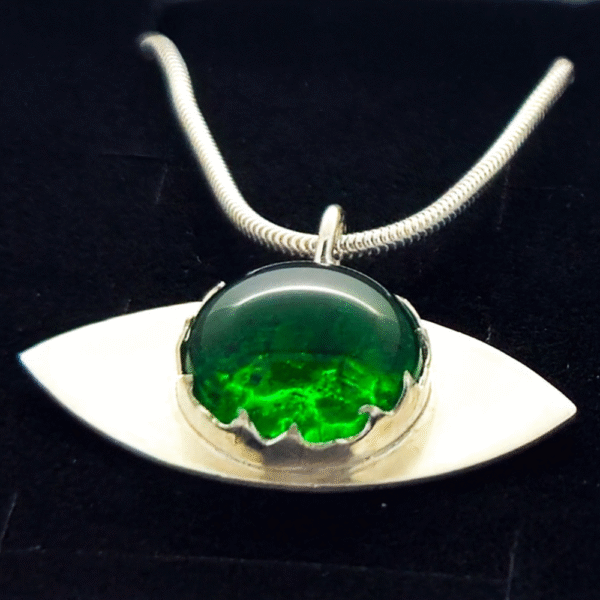 Close up handmade ashes in glass eye pendant necklace in sterling silver – memorial jewellery UK